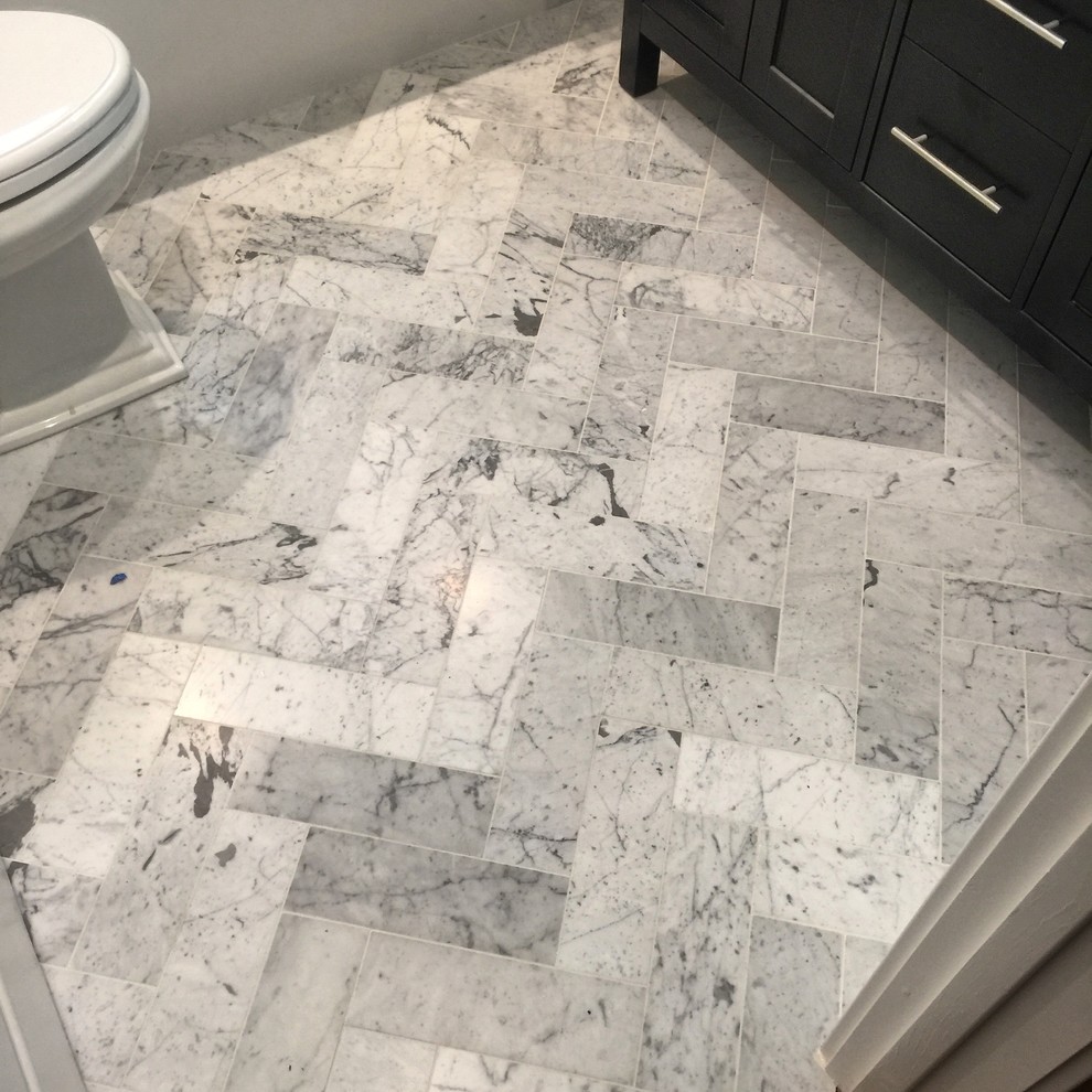 Photo of a small transitional powder room in San Francisco with shaker cabinets, black cabinets, a two-piece toilet, gray tile, white walls, marble floors, an undermount sink and marble benchtops.