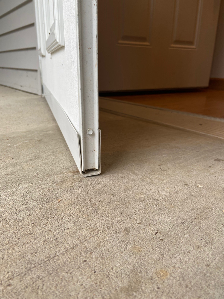 Front screen door drags on cement how can I fix this to allow a rug?
