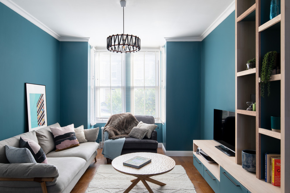 Ispirazione per un soggiorno di medie dimensioni e aperto con pareti blu, pavimento in legno massello medio, parete attrezzata e pavimento marrone