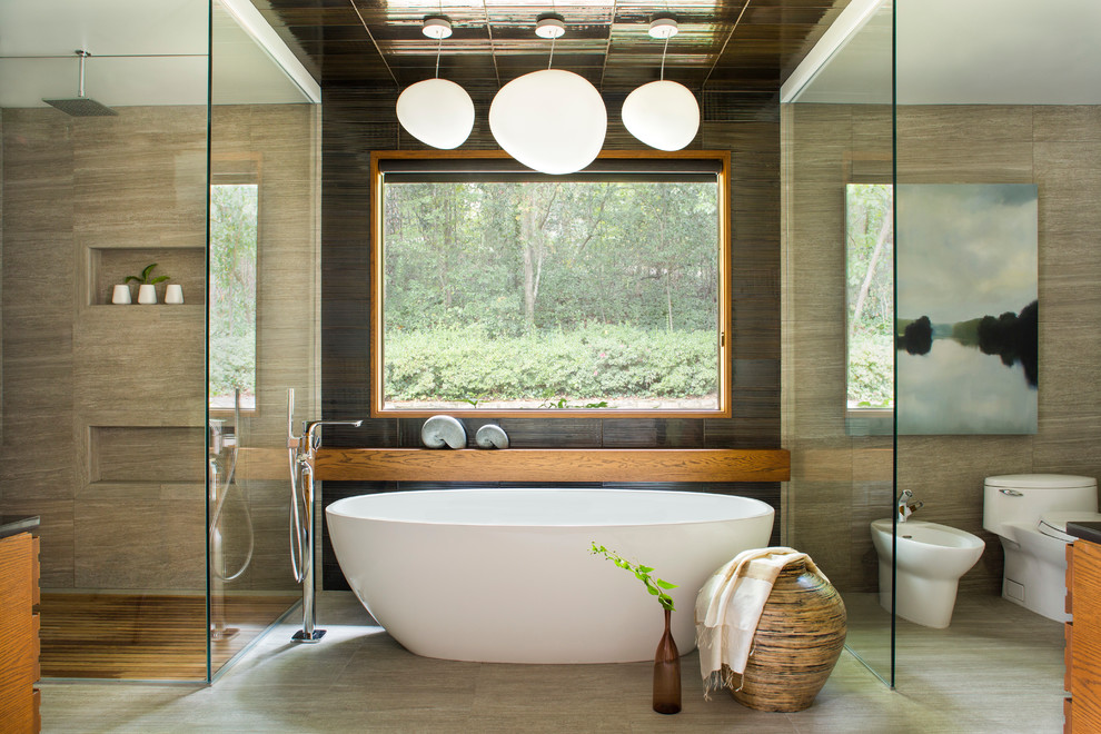 Photo of an asian master bathroom in Atlanta with medium wood cabinets, a freestanding tub, a corner shower, a one-piece toilet and beige tile.