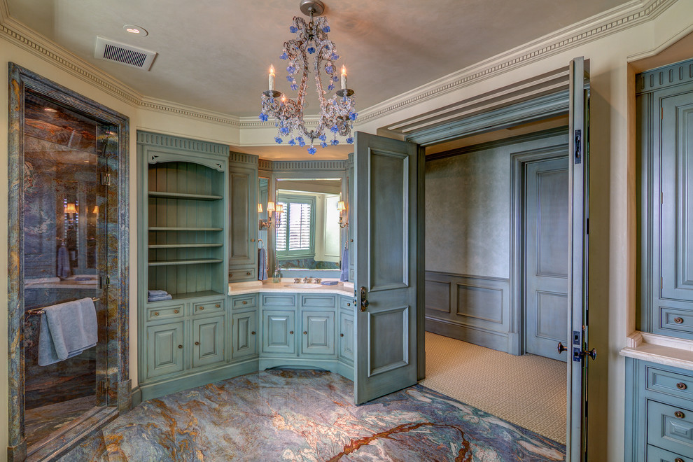 This is an example of a large mediterranean master bathroom in Los Angeles with an undermount sink, beaded inset cabinets, grey cabinets, marble benchtops, an undermount tub, a corner shower, gray tile, stone slab, beige walls and marble floors.