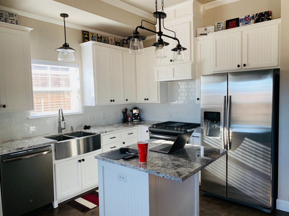 Example of a mid-sized transitional l-shaped eat-in kitchen design with a farmhouse sink, shaker cabinets, white cabinets, granite countertops, white backsplash, subway tile backsplash, stainless steel appliances, an island and gray countertops