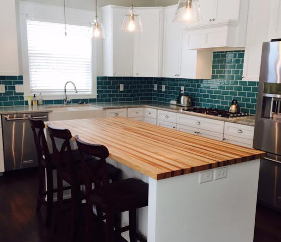 Photo of a large country single-wall open plan kitchen in Philadelphia with a farmhouse sink, beaded inset cabinets, white cabinets, wood benchtops, green splashback, ceramic splashback, stainless steel appliances, dark hardwood floors, with island, brown floor and multi-coloured benchtop.