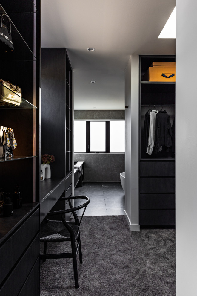 Cette photo montre un grand dressing moderne avec un placard sans porte et des portes de placard noires.