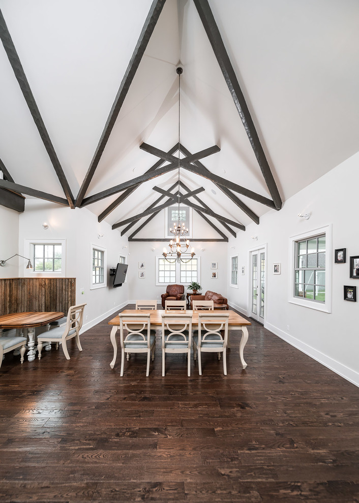 Example of a mid-sized transitional u-shaped dark wood floor and brown floor great room design with an undermount sink, shaker cabinets, white cabinets, quartz countertops, white backsplash, ceramic backsplash, stainless steel appliances and an island
