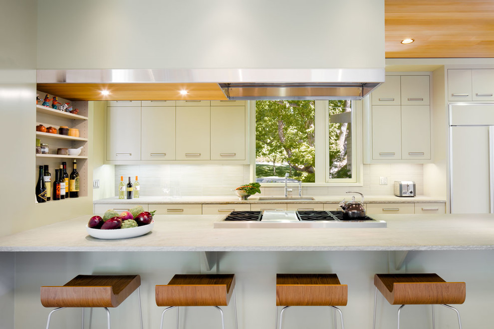 Design ideas for a mid-sized contemporary eat-in kitchen in San Francisco with flat-panel cabinets, with island, an undermount sink, white cabinets, white splashback, porcelain splashback, panelled appliances and quartzite benchtops.