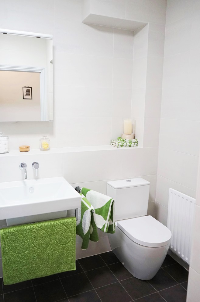 Small contemporary kids bathroom in London with a drop-in tub, white tile, ceramic tile, white walls, linoleum floors, a wall-mount sink, tile benchtops and a two-piece toilet.