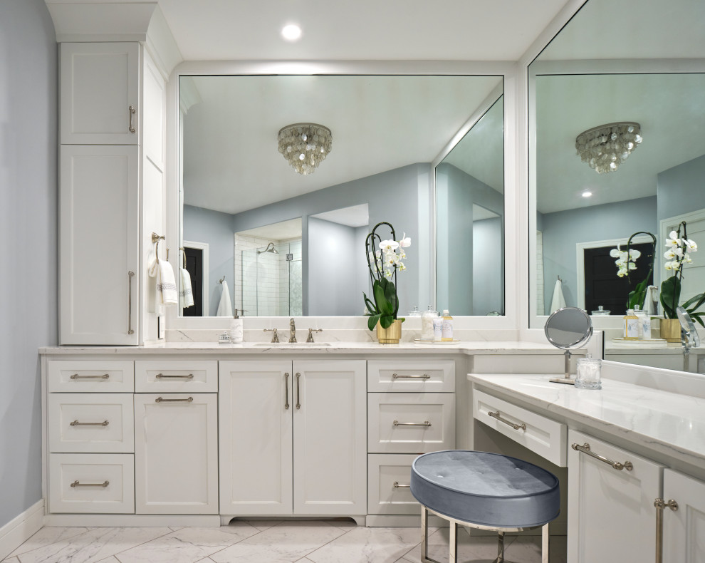 Photo of a large classic family bathroom in Omaha with shaker cabinets, white cabinets, an alcove bath, an alcove shower, a two-piece toilet, white tiles, mosaic tiles, blue walls, porcelain flooring, a submerged sink, engineered stone worktops, grey floors, a hinged door, white worktops, a wall niche, a single sink and a built in vanity unit.