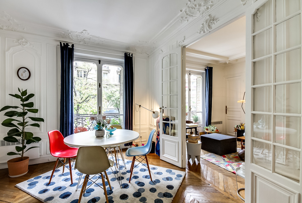 Large transitional open plan dining in Paris with white walls, medium hardwood floors and no fireplace.
