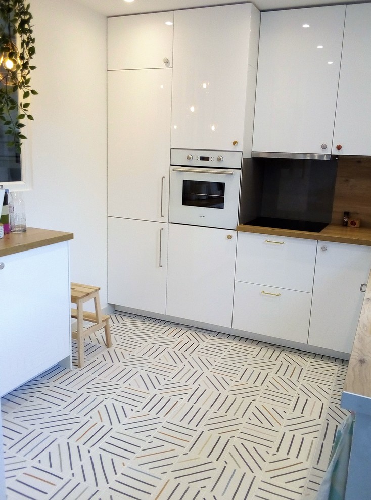 Design ideas for a small scandinavian l-shaped open plan kitchen in Montpellier with an undermount sink, beaded inset cabinets, white cabinets, wood benchtops, brown splashback, timber splashback, panelled appliances, cement tiles, no island, multi-coloured floor and brown benchtop.