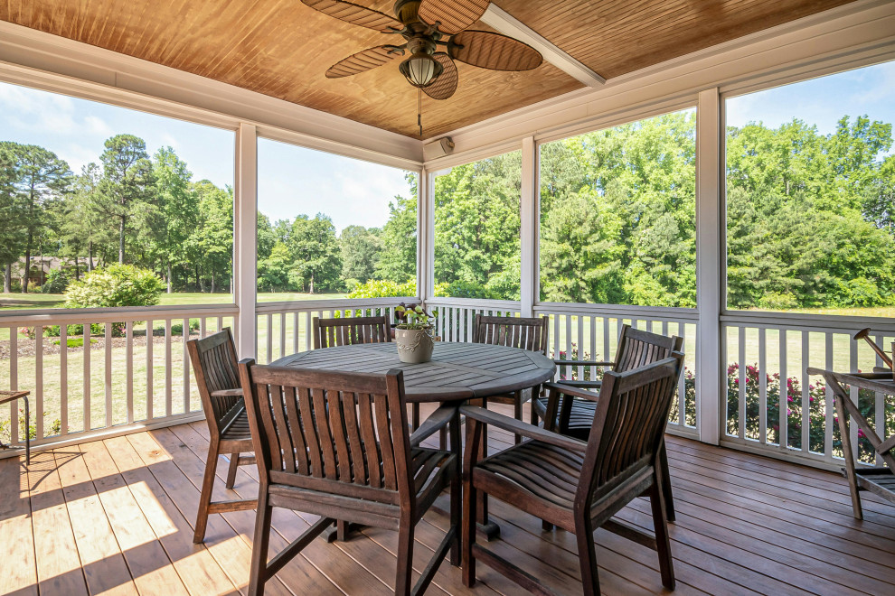 Covered outdoor patio with ceiling fan and seating on a bright summers day