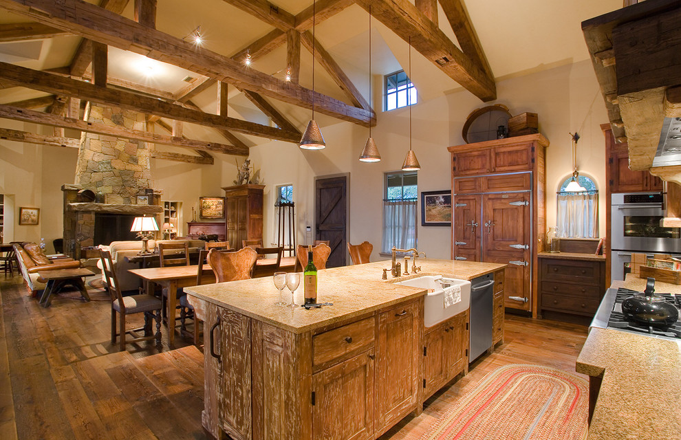 Inspiration for a mid-sized rustic l-shaped concrete floor eat-in kitchen remodel in Austin with a drop-in sink, flat-panel cabinets, blue cabinets, stainless steel countertops, brown backsplash, stainless steel appliances and no island