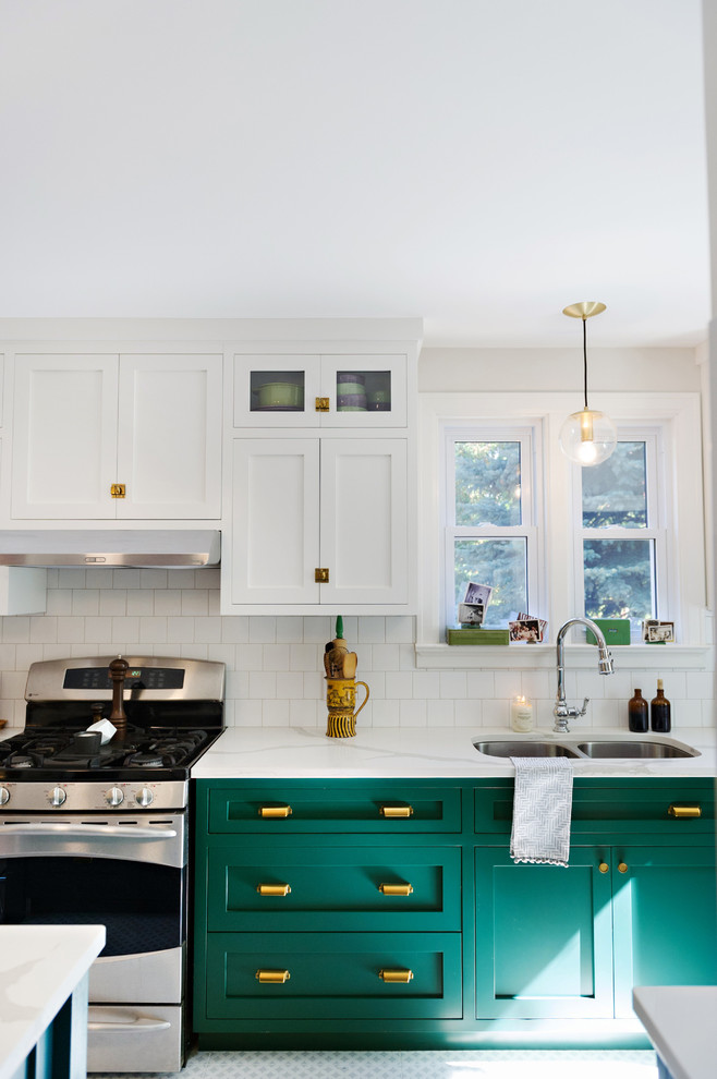 Example of a large transitional porcelain tile and multicolored floor enclosed kitchen design with a drop-in sink, shaker cabinets, white cabinets, marble countertops, white backsplash, ceramic backsplash, stainless steel appliances and an island