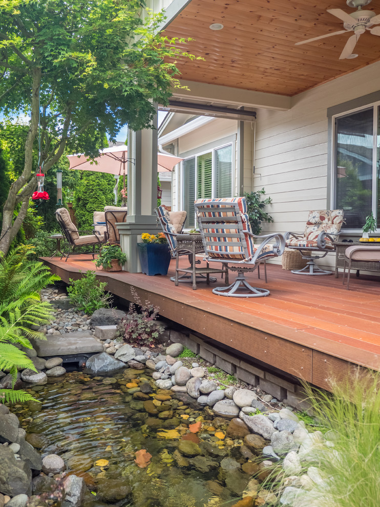 Photo of a small traditional backyard deck in Seattle with a roof extension.