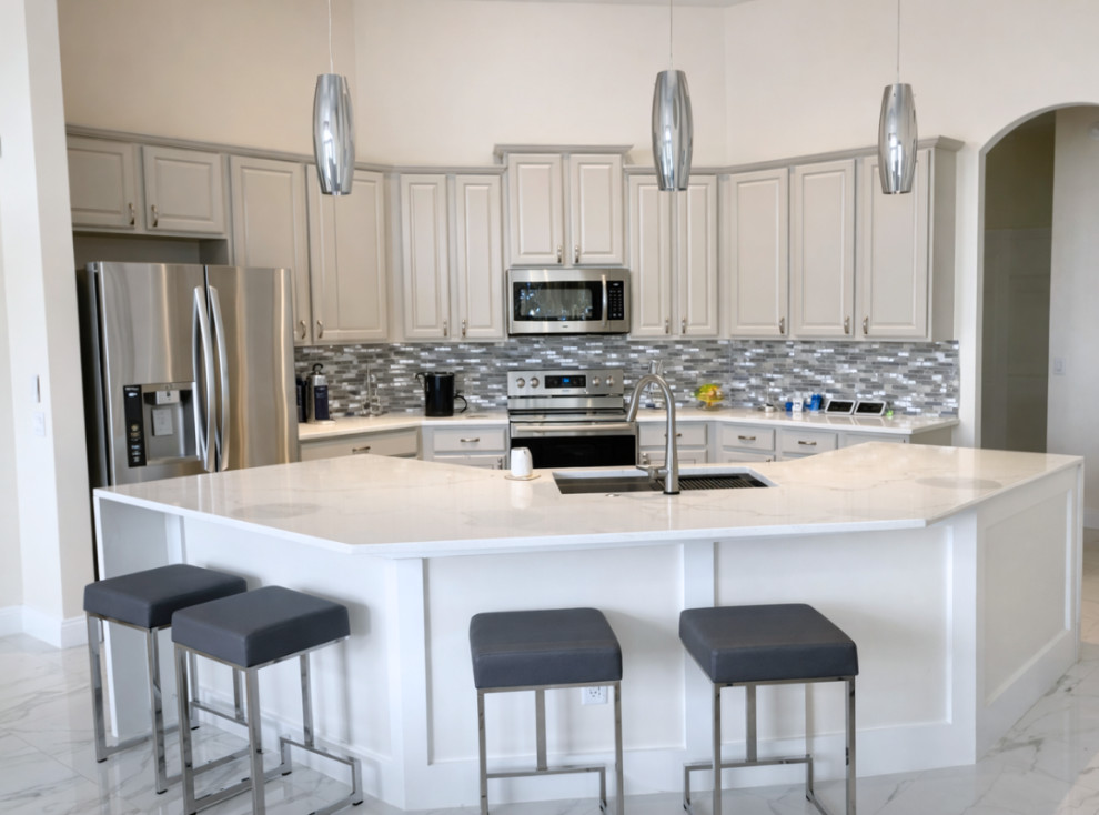 Kitchen - mid-sized transitional u-shaped porcelain tile and white floor kitchen idea with an undermount sink, raised-panel cabinets, white cabinets, quartzite countertops, gray backsplash, mosaic tile backsplash, stainless steel appliances, a peninsula and white countertops