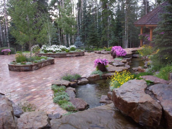 Design ideas for a huge rustic full sun backyard brick water fountain landscape in Denver.