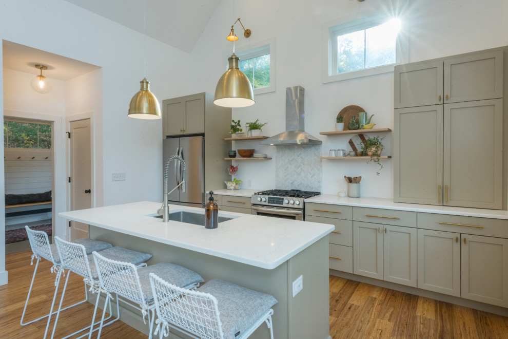 Photo of a mid-sized transitional single-wall eat-in kitchen in Other with an undermount sink, shaker cabinets, beige cabinets, quartz benchtops, white splashback, ceramic splashback, stainless steel appliances, bamboo floors, with island, brown floor and white benchtop.