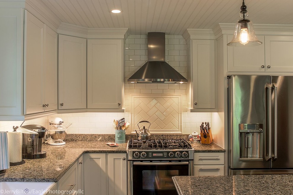 Inspiration for a large transitional l-shaped dark wood floor and brown floor eat-in kitchen remodel with a farmhouse sink, shaker cabinets, white cabinets, granite countertops, white backsplash, subway tile backsplash, stainless steel appliances and an island