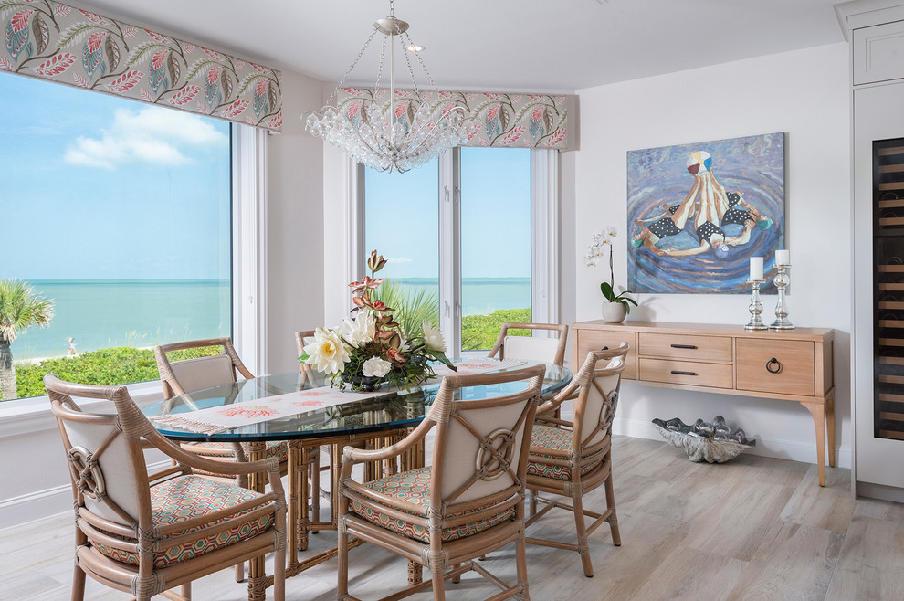 This is an example of a beach style dining room in Other with white walls, light hardwood floors and beige floor.