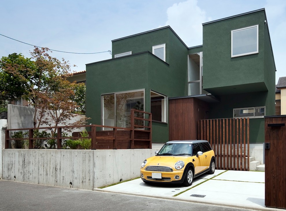 Contemporary two-storey green house exterior in Osaka with a shed roof and a metal roof.