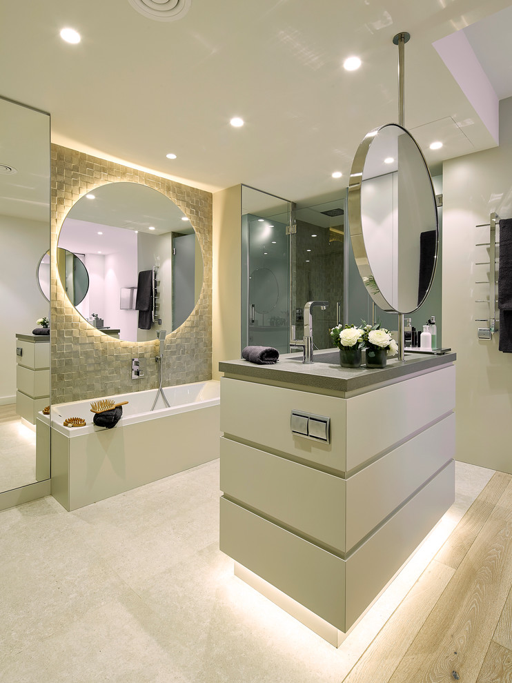 This is an example of a large contemporary master bathroom in Barcelona with flat-panel cabinets, an alcove tub, a shower/bathtub combo, multi-coloured walls, light hardwood floors and an integrated sink.
