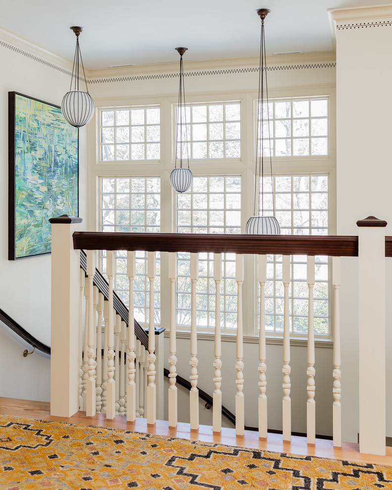 This is an example of a transitional hallway in Boston with white walls, light hardwood floors and beige floor.