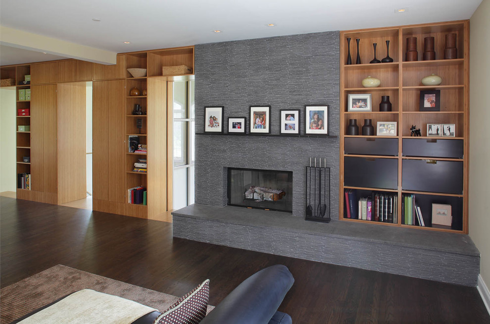 Contemporary family room in New York with beige walls, a standard fireplace and a stone fireplace surround.