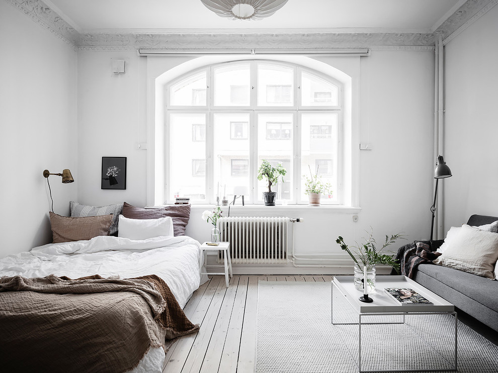 Mid-sized scandinavian master bedroom in Gothenburg with white walls, painted wood floors and white floor.