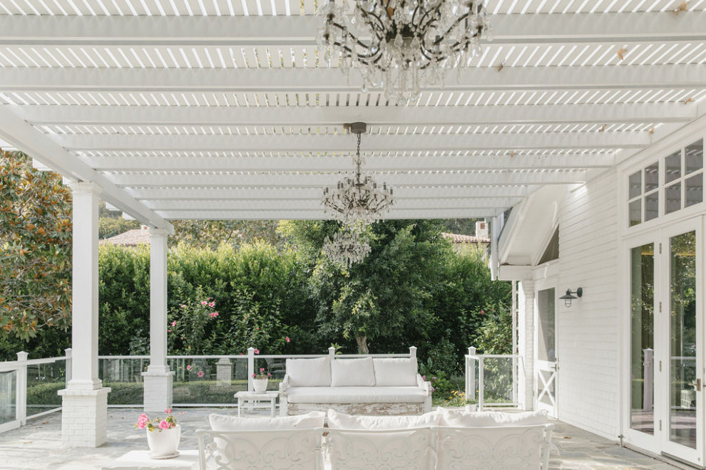 Inspiration for an expansive country side yard patio in Los Angeles with natural stone pavers and a pergola.
