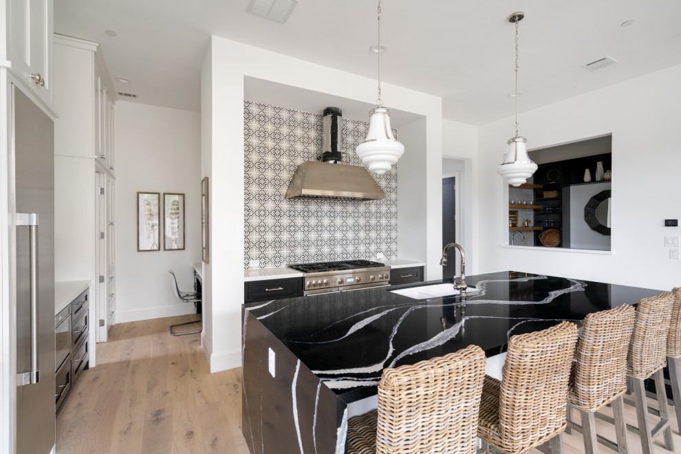 Huge transitional u-shaped medium tone wood floor and brown floor enclosed kitchen photo in Houston with an undermount sink, shaker cabinets, black cabinets, quartz countertops, multicolored backsplash, cement tile backsplash, stainless steel appliances, an island and black countertops
