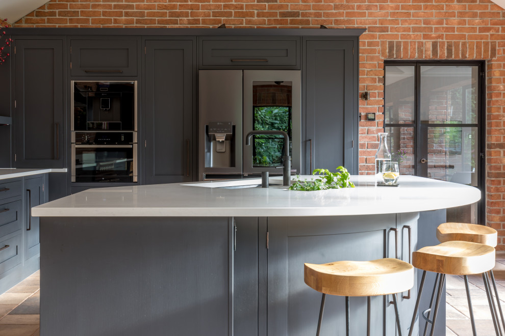 Foto på ett mellanstort industriellt vit kök, med blå skåp, bänkskiva i koppar och en köksö