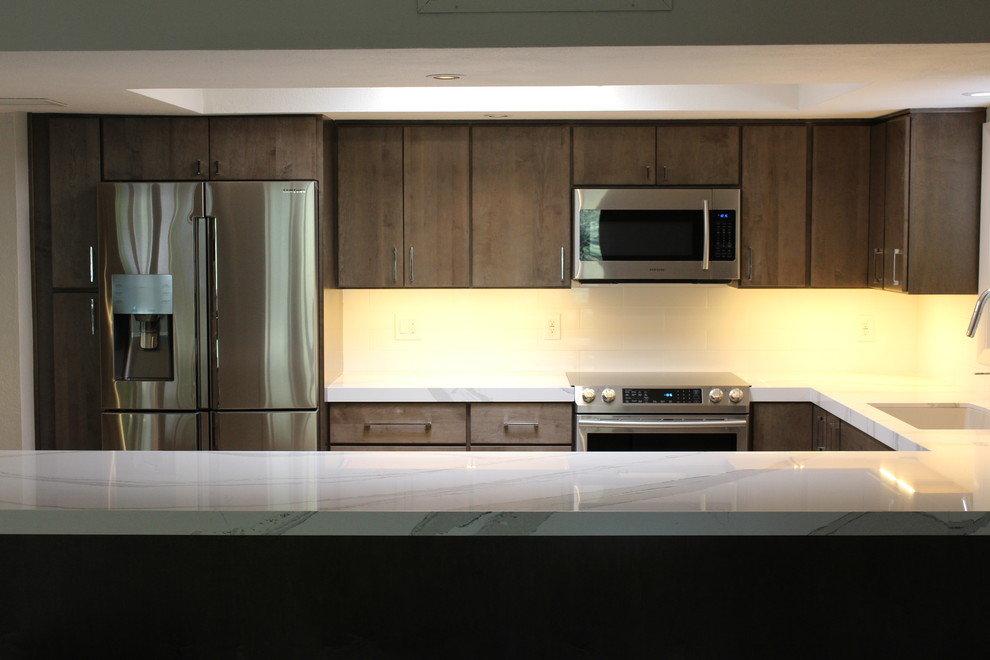 Mid-sized transitional u-shaped ceramic tile open concept kitchen photo in Phoenix with an undermount sink, flat-panel cabinets, gray cabinets, quartz countertops, white backsplash, porcelain backsplash, stainless steel appliances and a peninsula