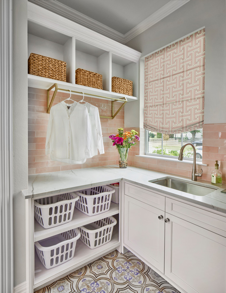 Bild på en vintage tvättstuga, med en undermonterad diskho, rosa stänkskydd, stänkskydd i keramik, klinkergolv i porslin och en tvättmaskin och torktumlare bredvid varandra