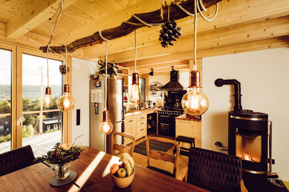 Offene, Mittelgroße Urige Küche in U-Form mit Arbeitsplatte aus Holz, hellem Holzboden und Holzdielendecke in Sonstige