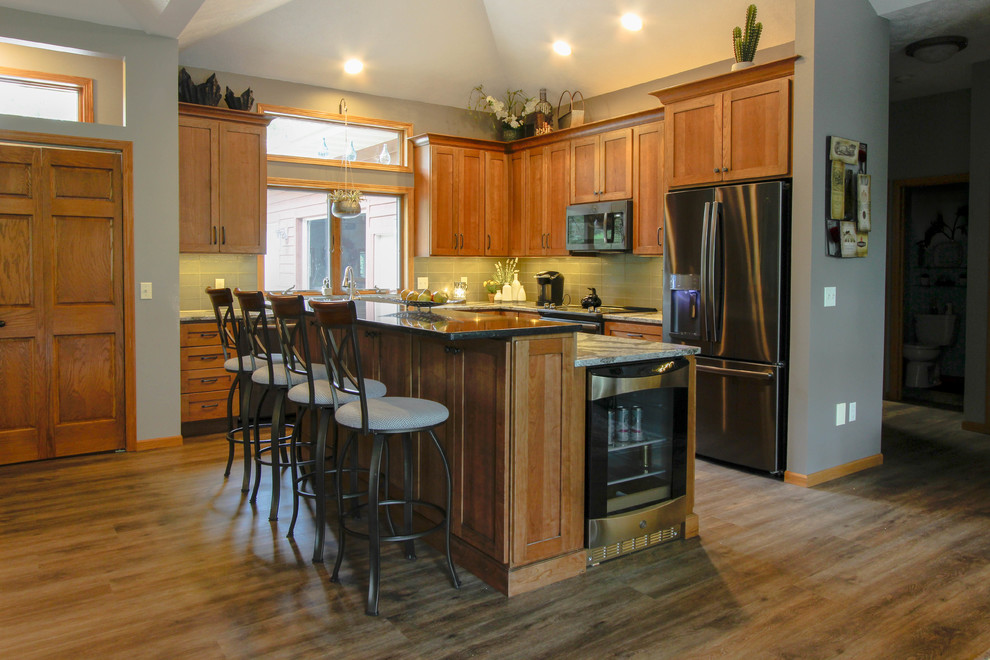 Example of a mid-sized eclectic l-shaped open concept kitchen design with shaker cabinets, distressed cabinets, quartzite countertops, green backsplash, glass tile backsplash, stainless steel appliances and an island