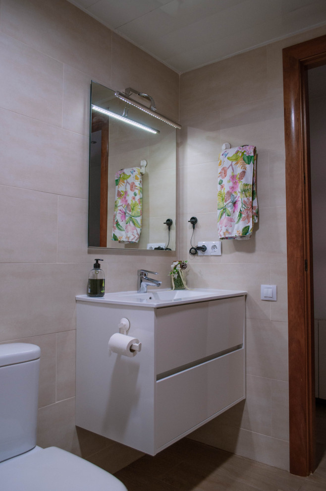 Inspiration for a mid-sized traditional master bathroom in Barcelona with flat-panel cabinets, white cabinets, a drop-in tub, a two-piece toilet, beige tile, ceramic tile, beige walls, ceramic floors, a vessel sink, brown floor, a hinged shower door, white benchtops, an enclosed toilet, a single vanity and a freestanding vanity.