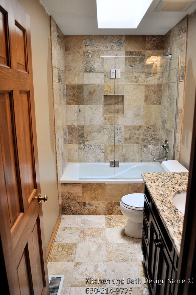 This is an example of a mid-sized traditional bathroom in Chicago with an undermount sink, recessed-panel cabinets, dark wood cabinets, granite benchtops, an alcove tub, an alcove shower, a two-piece toilet, stone tile, travertine floors and beige walls.