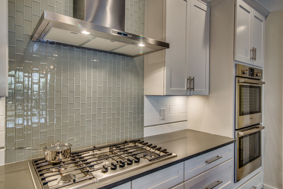 Transitional dark wood floor kitchen photo in Nashville with an undermount sink, white cabinets, gray backsplash, stainless steel appliances and an island