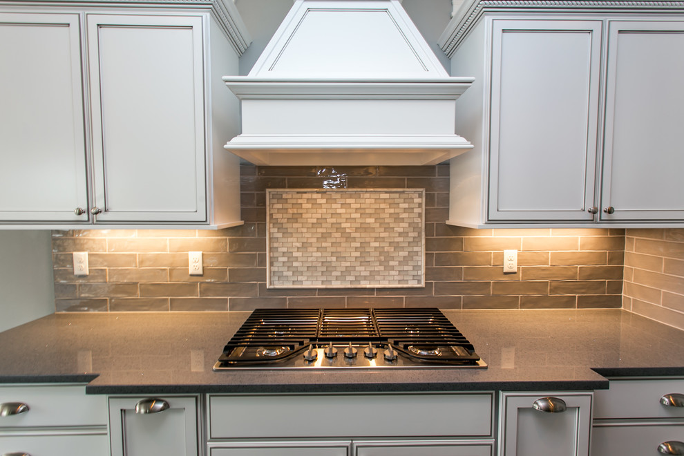 Inspiration for a mid-sized transitional l-shaped dark wood floor open concept kitchen remodel in Seattle with an undermount sink, shaker cabinets, white cabinets, quartz countertops, gray backsplash, glass tile backsplash, stainless steel appliances and an island