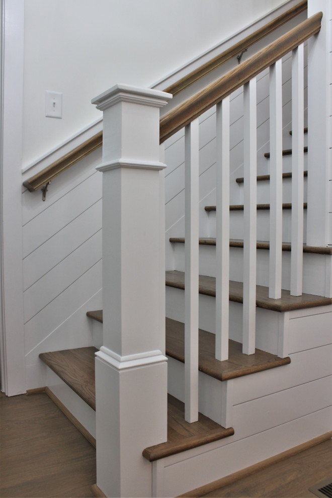 Стильный дизайн: прямая деревянная лестница с деревянными ступенями, деревянными перилами и стенами из вагонки - последний тренд