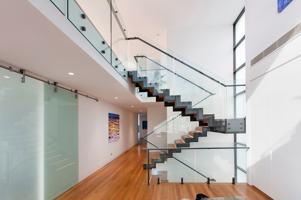 Large contemporary wood u-shaped staircase in Newcastle - Maitland with wood risers and metal railing.