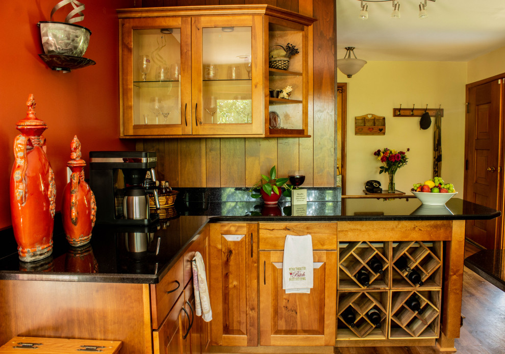 Open concept kitchen - large rustic u-shaped medium tone wood floor and brown floor open concept kitchen idea with a farmhouse sink, raised-panel cabinets, medium tone wood cabinets, quartz countertops, stainless steel appliances, an island and black countertops