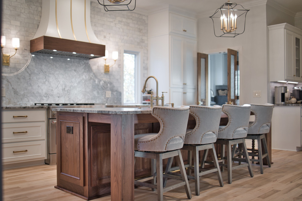 Inspiration for a large eclectic l-shaped eat-in kitchen in Nashville with a farmhouse sink, beaded inset cabinets, white cabinets, granite benchtops, grey splashback, marble splashback, stainless steel appliances, with island and grey benchtop.