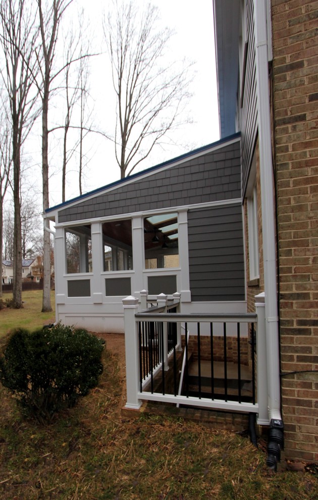 Photo of a large transitional backyard screened-in verandah in DC Metro with tile and a roof extension.