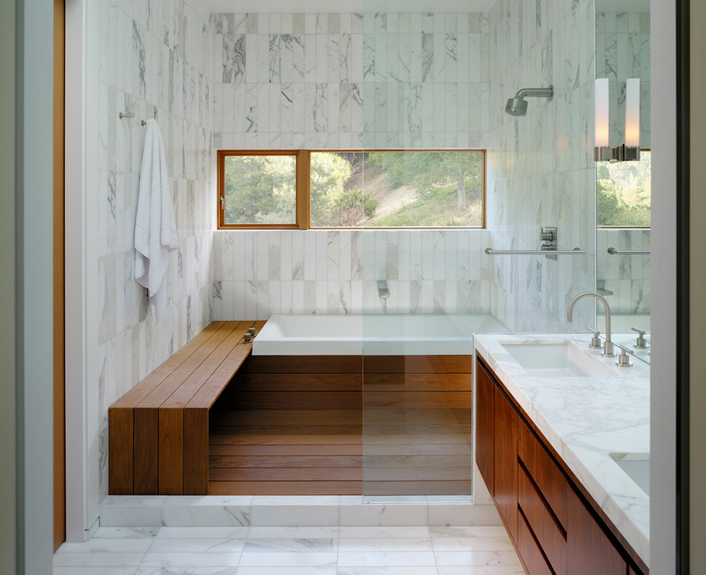 This is an example of a contemporary bathroom in San Francisco with a drop-in tub and flat-panel cabinets.