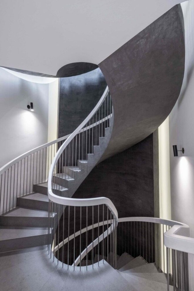 Inspiration for a mid-sized contemporary concrete spiral staircase in London with concrete risers, metal railing and decorative wall panelling.