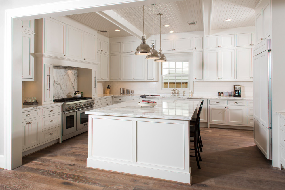 Inspiration for an expansive transitional u-shaped separate kitchen in Houston with an undermount sink, shaker cabinets, medium wood cabinets, marble benchtops, white splashback, subway tile splashback, stainless steel appliances, medium hardwood floors, with island, brown floor, white benchtop and exposed beam.