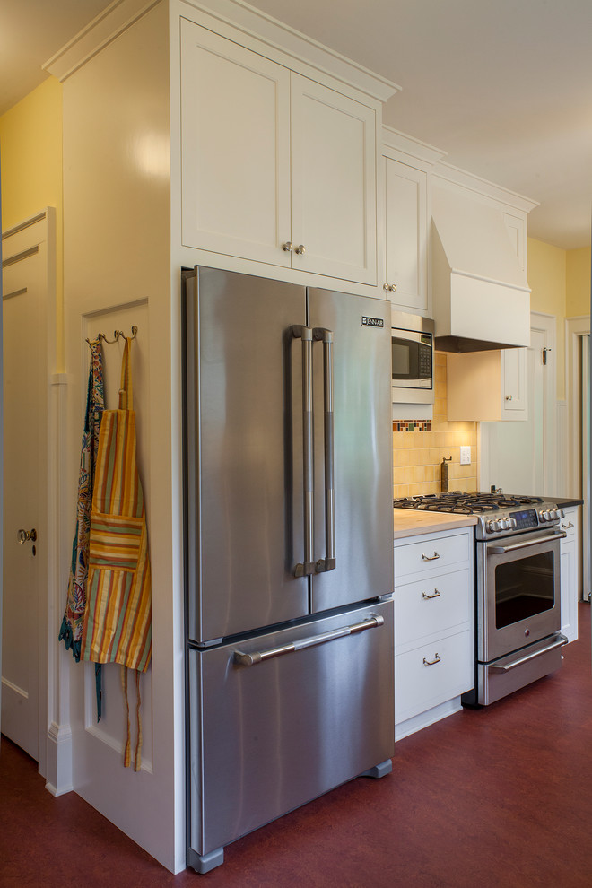 This is an example of a small arts and crafts single-wall eat-in kitchen in Portland with a farmhouse sink, shaker cabinets, white cabinets, stainless steel appliances, no island, granite benchtops, yellow splashback, ceramic splashback and linoleum floors.