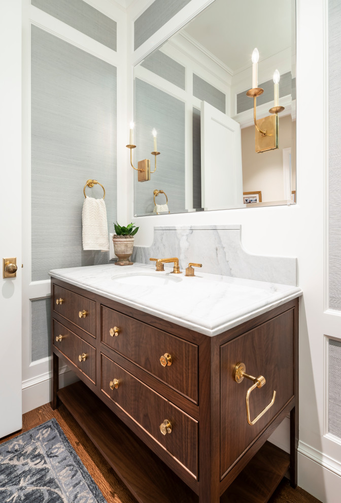 Photo of a mid-sized transitional powder room in Salt Lake City with furniture-like cabinets, medium wood cabinets, grey walls, medium hardwood floors, an undermount sink, brown floor and white benchtops.