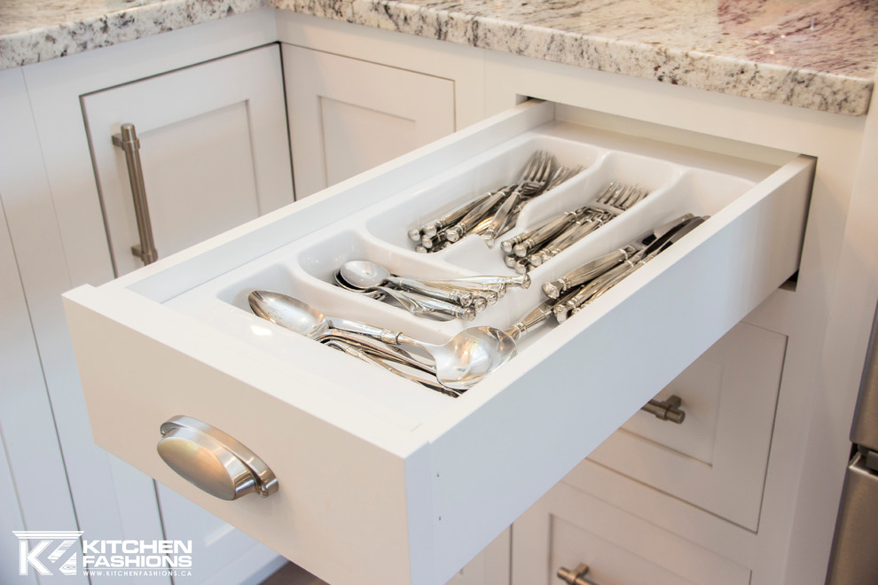 Inspiration for a large transitional u-shaped light wood floor home design remodel with a farmhouse sink, shaker cabinets, white cabinets, granite countertops, white backsplash, subway tile backsplash, stainless steel appliances and no island